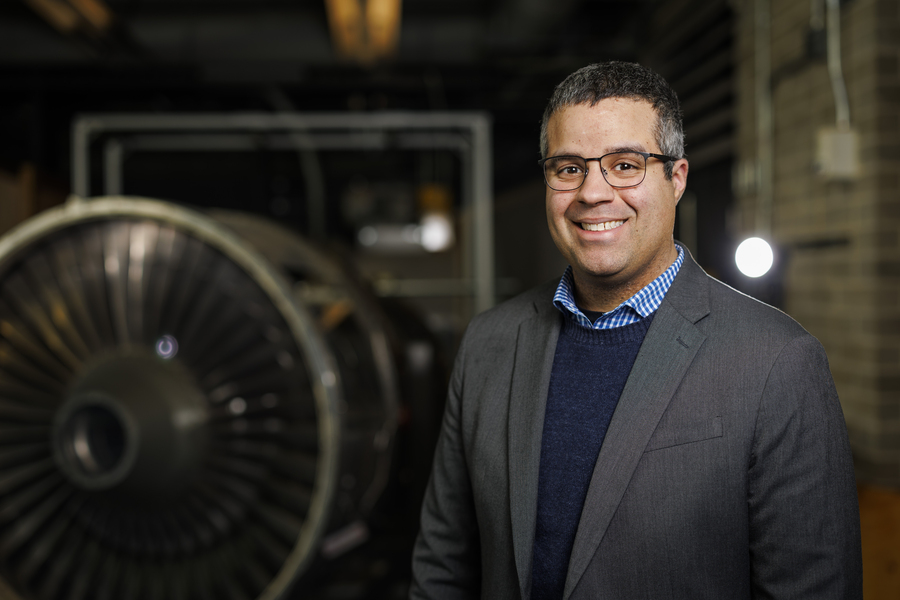 Richard Linares stands in front of a large turbine.