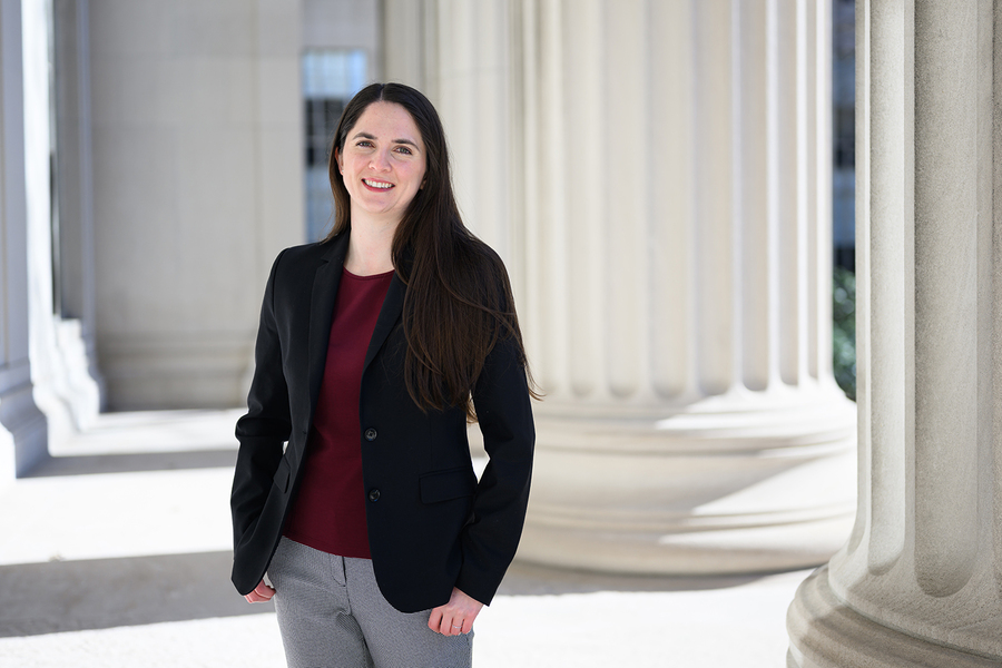 Lauren Fortier poses outdoors amidst large architectural columns