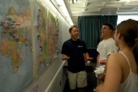 Sophomore in mechanical engineering Jon Wu (left) shares a laugh with incoming freshmen Brian Schmidt and Laura Daher in front of the map on which freshmen were asked to put a tack to mark where they come from.