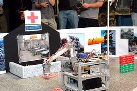 A rescue robot carries a doll, representing a victim of disaster, to the 'emergency room' during the course 2.12 demonstration held Wednesday, Dec. 14, in the d'Arbeloff Lab.