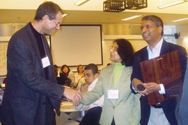 Paul Edelman '78 receives the first Desh and Jaishree Deshpande UPOP Service Award from the Deshpandes.
