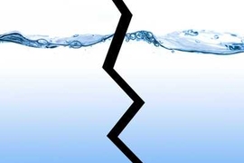 Bubbly wave of water with a jagged black line splitting the image in half