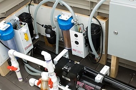 In the system, a solar photovoltaic panel powers pumps that push seawater through a permeable membrane to remove salt and other minerals.