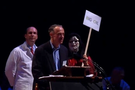 Eric Adams, senior research engineer in the Department of Civil and Environmental Engineering, makes his portion of a one-minute acceptance speech at the 2010 Ig Nobel Prize ceremony, as his co-winners Scott Socolofsky SM ’97, PhD ”01 and Stephen Masutani (dressed as the “Star Wars” tyrant Emperor Palpatine) await their 30 seconds.