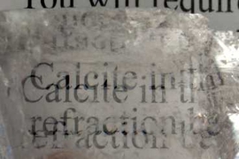 This image shows a calcite crystal laid upon a paper, causing all the letters to show double refraction.