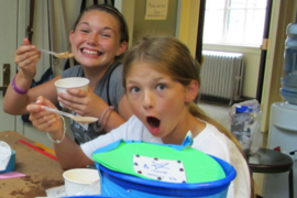 With their ice cream makers that they designed and built in the foreground, these girls enjoy the sweet results of their labors.