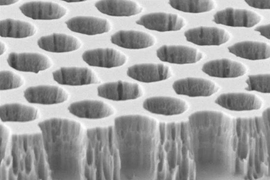 A microscope image of the tungsten photonic crystal structure reveals the precise uniform spacing of cavities formed in the material, which are tuned to specific wavelengths of light.