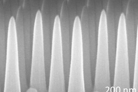 Through a process involving thin layers of material deposited on a surface and then selectively etched away, the MIT team produced a surface covered with tiny cones, each five times taller than their width. This pattern prevents reflections, while at the same time repelling water from the surface.