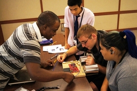 Instructor Raoul Ouedraogo (left) shows the students the proper wiring needed on a circuit board for their self-built radar.