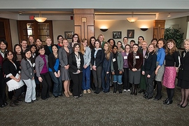 About 35 people pose together in an indoor lounge