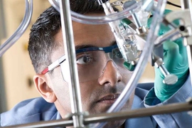 Man holding chemistry equipment up to look at it