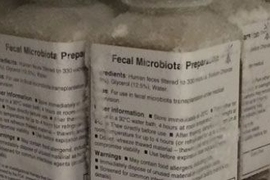 new research in microbiology 5 labeled bottles of fecal microbiota preparate show lists of text.