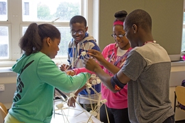 Middle school students Halle Armstrong, Jeffery Alphonso, Angelique Jean-Noel, and Kamaru Oseni use wooden skewers to build marshmallow towers on the first day of Engineering Design in the 2015 MIT STEM Summer Institute.