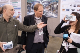 Josh Stillerman (left) and Bob Mumgaard help guide conference attendee Deedee Ortiz through virtual rooms of a 3-D tokamak fusion device.