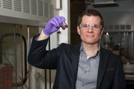 Robert Macfarlane, the AMAX Assistant Professor of Materials Science and Engineering at MIT, holds vials of gold nanoparticles. Macfarlane designs nanoscale crystal structures whose assembly is activated by mutually attractive “sticky ends.”