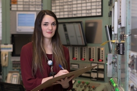 Sara Hauptman stands in the control room of MIT's Nuclear Reactor Lab. 