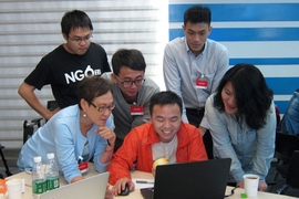 Jing Wang (bottom left), director of the MIT New Media Action Lab, facilitates a civic hackathon in collaboration with Tencent Cloud developers in Shenzhen, China. Wang and her nonprofit, NGO2.0, work to bridge the digital gap to improve social welfare for underserved populations in rural and urban China.