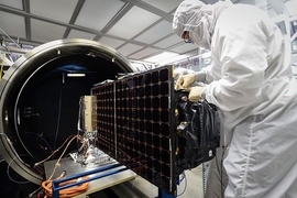 An engineer installs SensorSat, developed at Lincoln Laboratory, in the thermal-vacuum chamber used for testing the satellite's tolerance of conditions in space. 