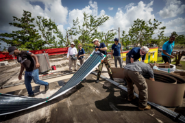 A team in the coastal town of Loíza, Puerto Rico, begins rolling out the first of 16 solar modules from MIT Lincoln Laboratory and Infinitum Humanitarian Systems (IHS). Left to right: Abdoun of the Boys and Girls Club; George Villec, president of GeoInnovation; Denisse Abdo, dietician and translator; Erik Limpaecher of Lincoln Laboratory; Alex Hatoum, IHS managing director; Eric Rasmussen, IHS CE...
