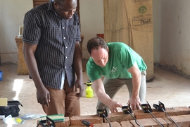 MIT D-Lab research scientist and CITE research affiliate Eric Verploegen (right) installs sensors on an evaporative refrigerator with Ousmane Sanogo of the World Vegetable Center in Mali.
