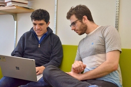 Researchers have developed a flexible way of combining deep learning and symbolic reasoning to teach computers to write short computer programs. Here, Armando Solar-Lezama (left), a professor at CSAIL, speaks with graduate student Maxwell Nye. 