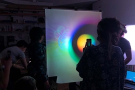 Prathima Muniyappa (with camera) and other class members examining a student demo. In studying various ambiguous images and works, students discover how emotional content and prior experiences contribute to what we think we see. 