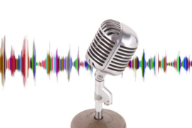 Photo of a radio-style microphone in front of a multicolor illustration of a sound wave