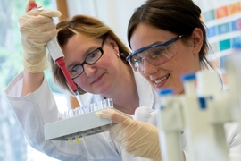 Photo of two female scientists in a lab experimenting with test tubes