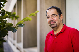 Photo of Daron Acemoglu next to a building