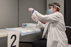 Health care worker filling syringe
