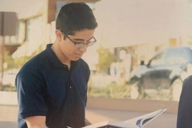 Photo of Sergio Dominguez sitting on some steps and reading a book