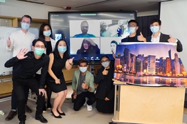 Photo of eight masked students posing with their smart locker prototype. Four more are on a screen behind them.