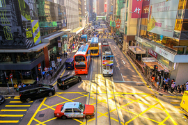 Photo of a busy city intersection, with vehicles backed up trying to make a turn onto a high-traffic street