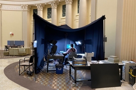 Photo of imaging equipment surrounded by a black tent inside a library room with ornate columns