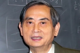 Portrait photo of Professor Emeritus Sow-Hsin Chen, dressed in a suit and tie and standing in front of a blackboard.
