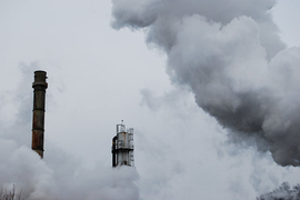 Photo of two smokestacks peeking through clouds of smoke and steam