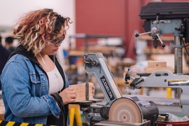 A woman using a power tool in a workshop