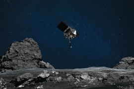 Photorealistic illustration of the OSIRIS-REx spacecraft, silver with a cone front and two wings, hovering above a grey, rocky surface with a dark blue background scattered with faint stars.