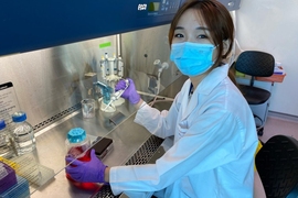 Photo of postdoc Huang Jiayi working at a lab bench