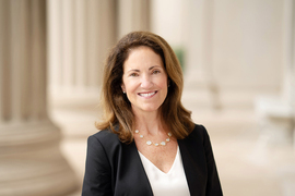 Portrait photo of Cynthia Barnhart standing in front of some large columns