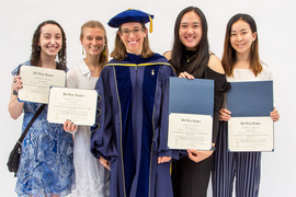 Photo of Emily Richmond Pollock in a blue doctoral gown and cap along with Eva Demsky, Anna Aldins, Shulammite Lim, and Stephanie Fu, each of whom holds her P.B.K. certificate