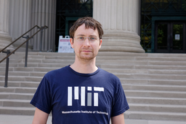 Photo of Johannes Kalliauer in front of MIT's main entrance, which features stone steps leading to large columns and glass doors.