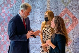 MIT Professor Sarah Williams discusses research with two World Food Program board members in front of a multi-colored tapestry.