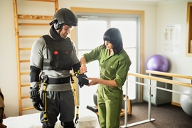 Photo of a woman fitting actor Chris Hemsworth for the AGNES suit