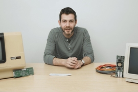 research papers on artificial intelligence and ipr Jacob Andreas leans forward with his arms resting on the table, speaking to the photographer. Outdated computer hardware is on either side of him.