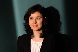 Headshot of journalist Gabriela Sá Pessoa in front of a plain blue wall.