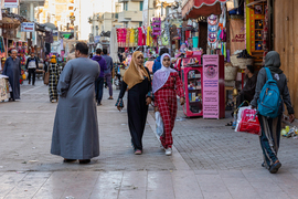Women walking through a busy street market in Egypt