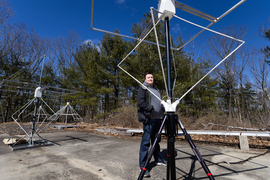 John Swoboda stands outside next to equipment resembling antennae.
