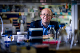 Michael Birnbaum in the lab, with blurry equipment in foreground.