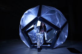 In a darkened room, Katie Chun steps out of the Momo habitat, a geodesic dome-like structure.